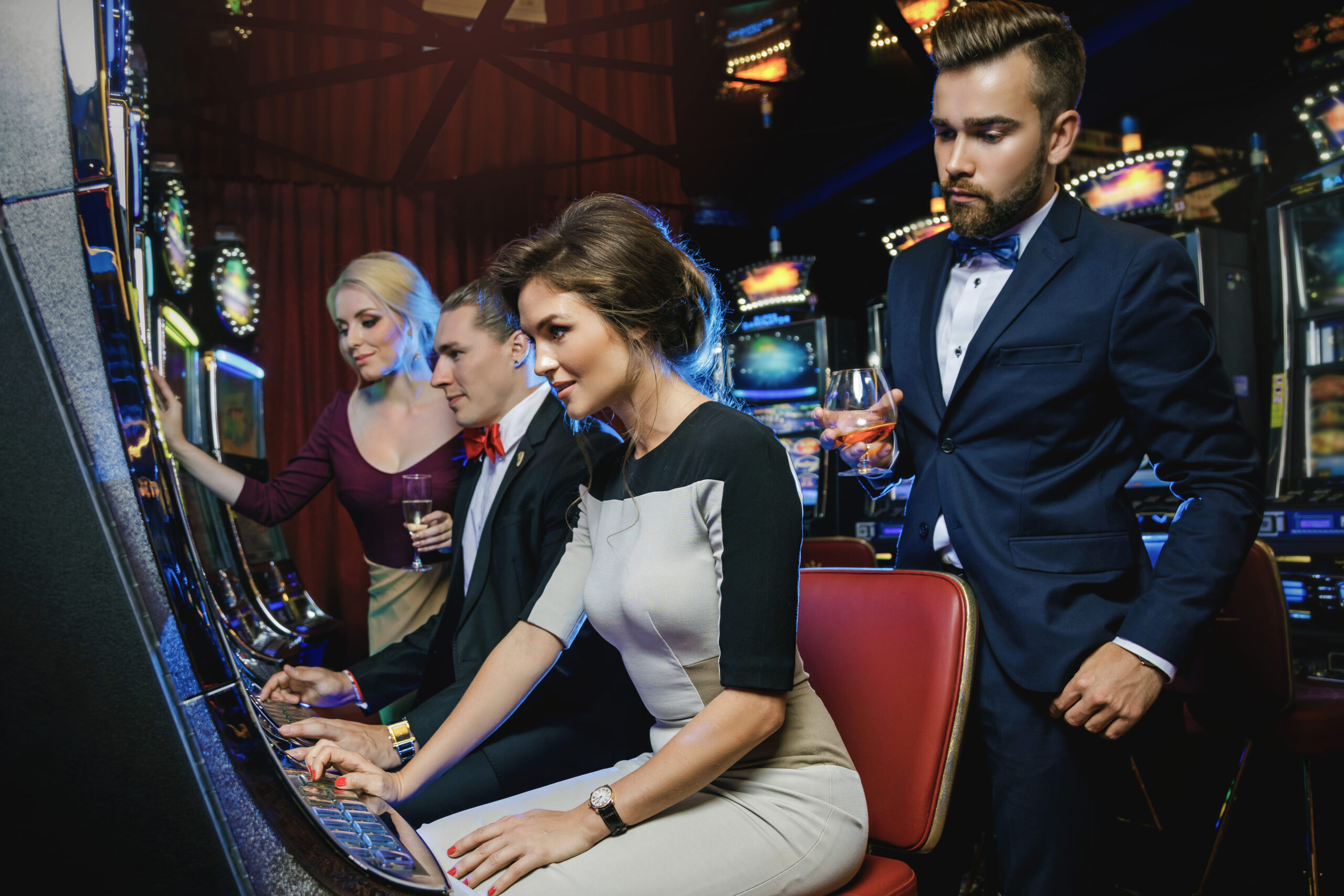 Group of friends playing slot machines in the casino